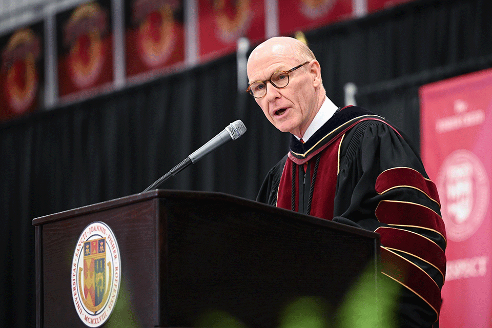 President Rooney addresses graduate at a 2023 Commencement ceremony.