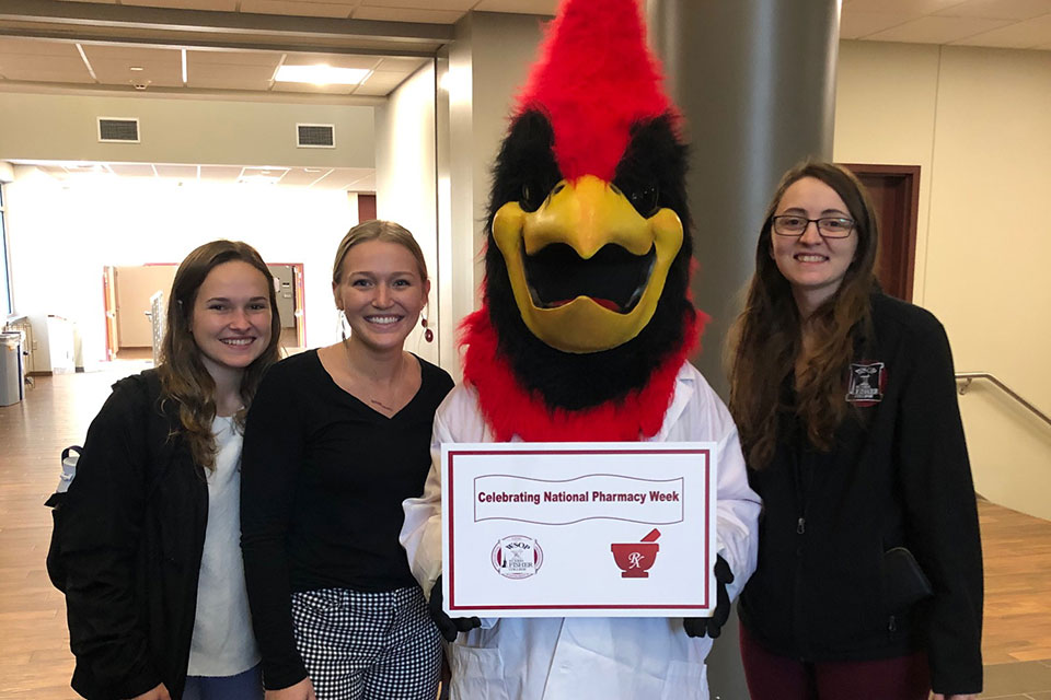 Pharmacy students pose with the Cardinal during a National Pharmacy Week celebration.