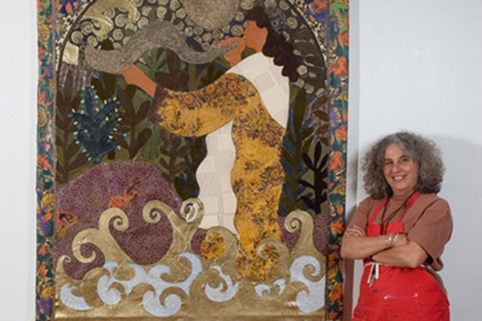 Artist Lynne Feldman poses in front of one of her works of art.
