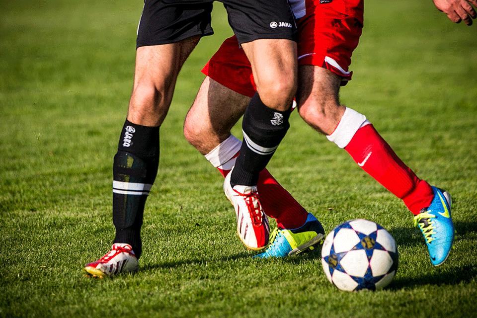 Soccer players battle for a ball on the field.