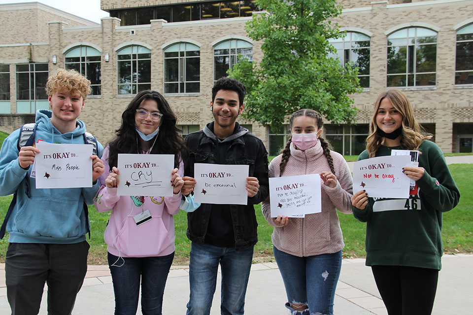Students hold up signs of encouragement.