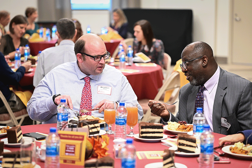 Two employees talk at the annual service recognition luncheon.