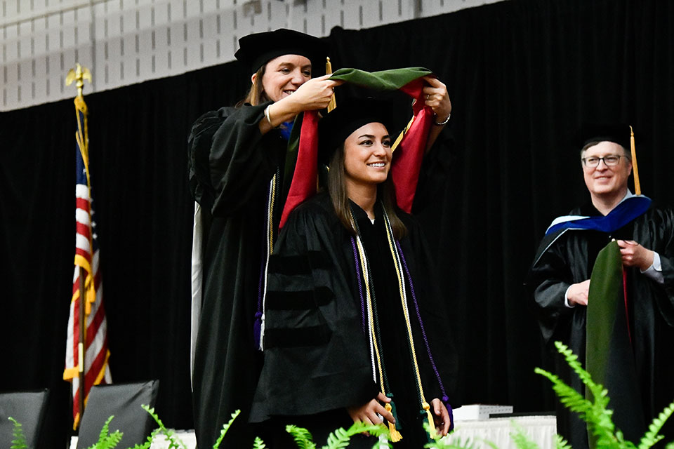 A member of the Wegmans School of Pharmacy Class of 2019 receives her doctoral hood.
