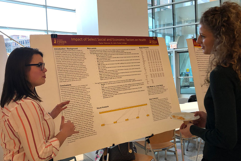 Taylor Palermo shares her research with a conference attendee.