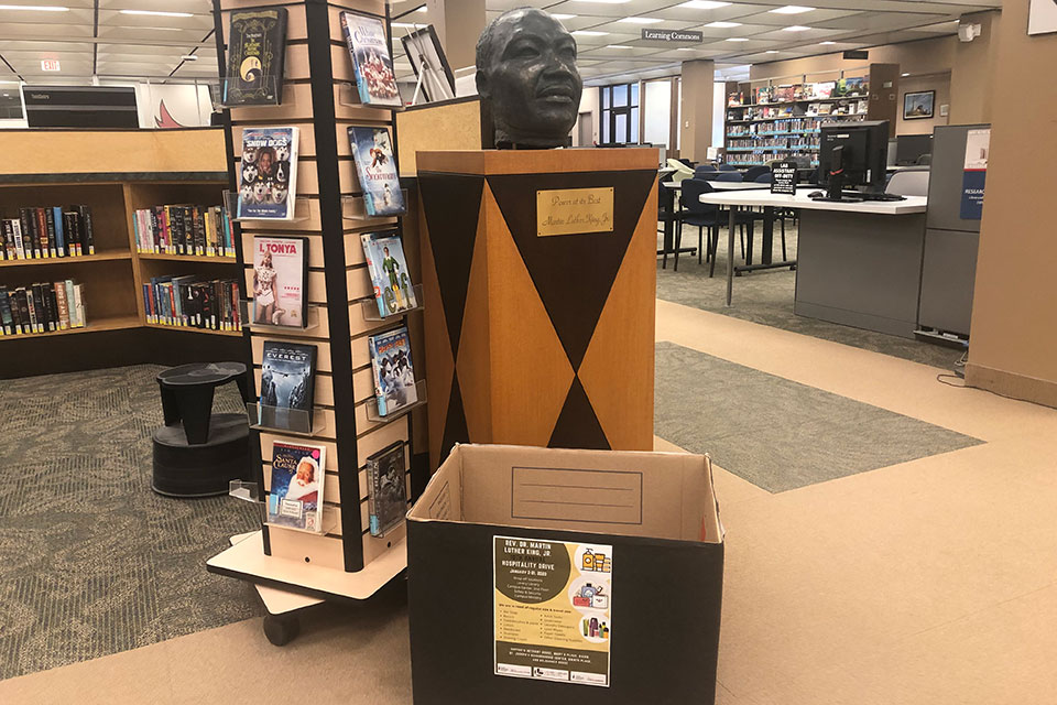 A donation bin sits in front of a statue of Martin Luther King Jr. in Lavery Library.