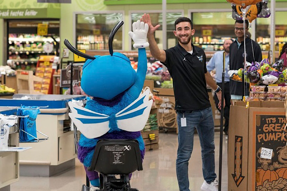 Anthony Loussedes high-fives the Charlotte Hornet during his internship.
