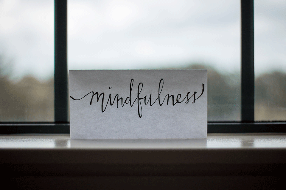 The word mindfulness is written in cursive on a placard.