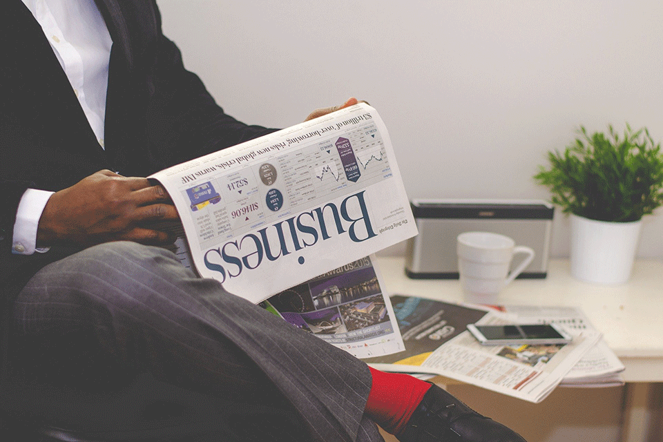A person reads a business newspaper.