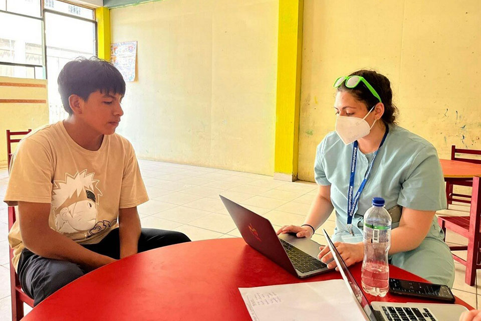 A pharmacy student counsels a young patient at a health clinic in Peru.