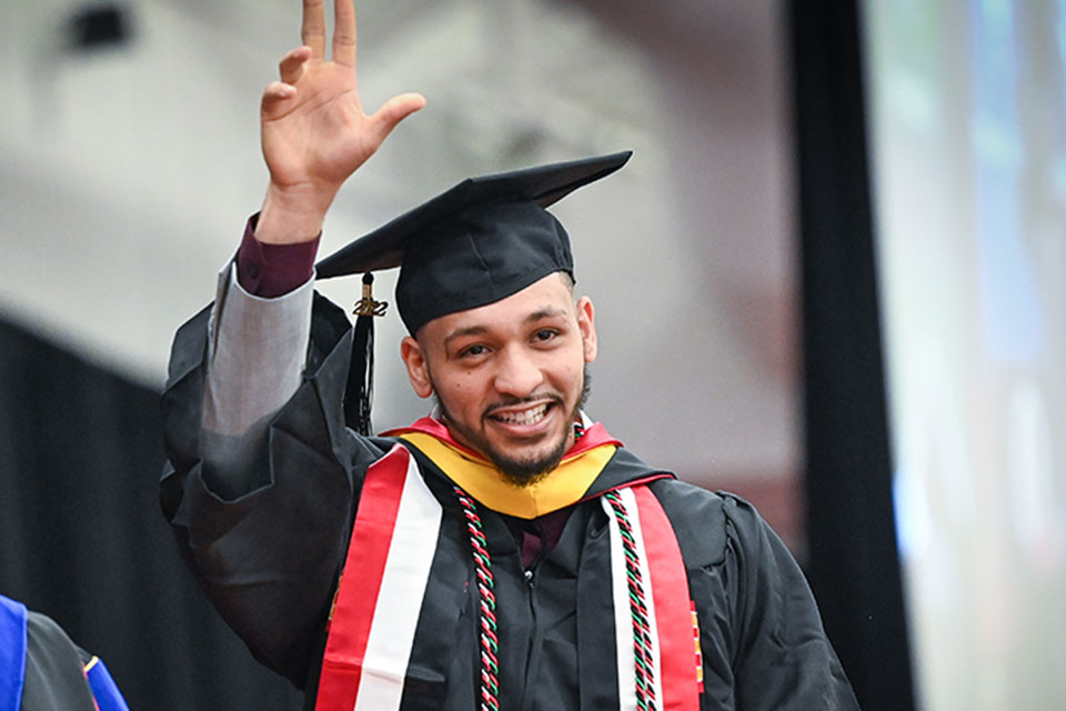 Wegmans School of Nursing graduate Abdulhady Homed walks across the stage after receiving his diploma.
