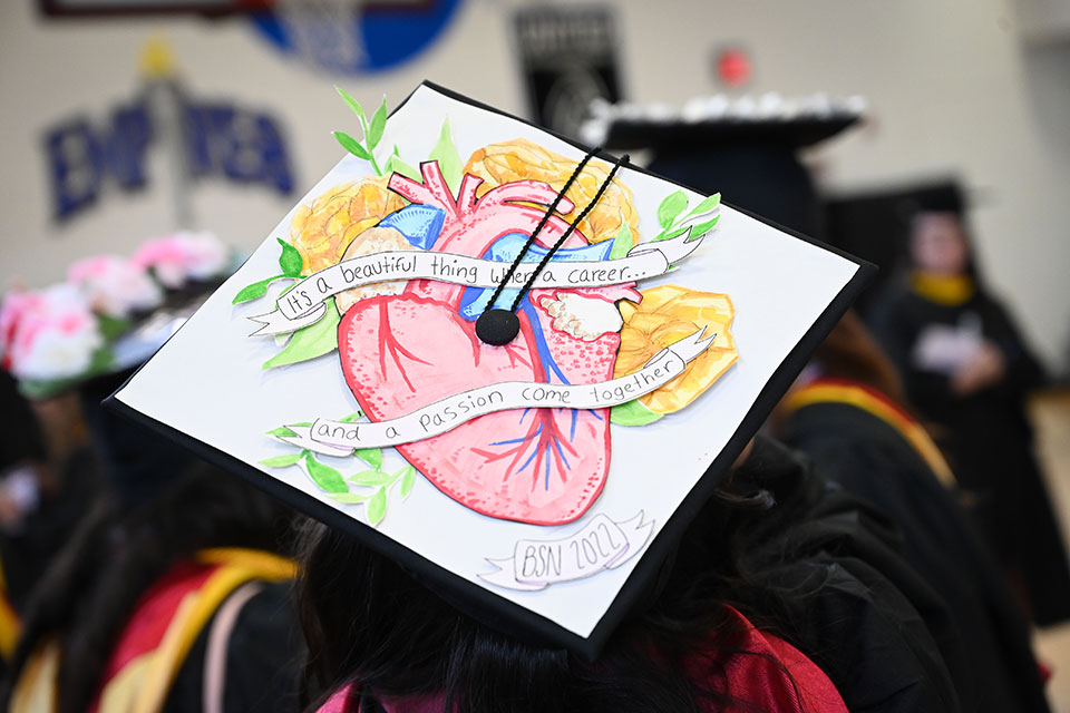 A graduate of the Wegmans School of Nursing shows off her mortar board at Commencement.