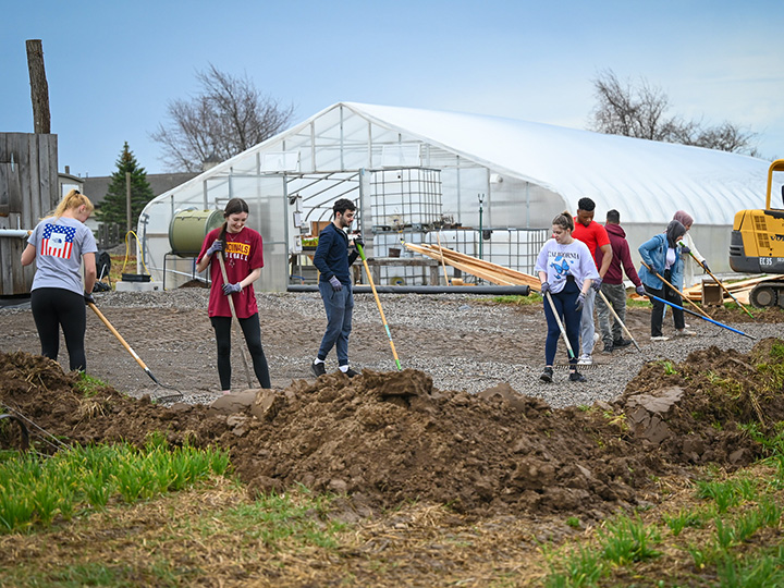 Students spreading gravel outside during their annual day of service.