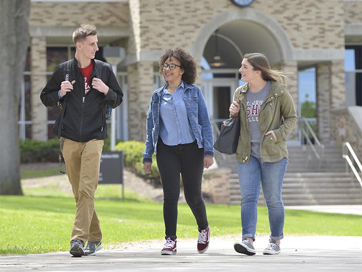 Three students walk together on campus.