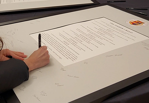 A student signing the Fisher Creed.