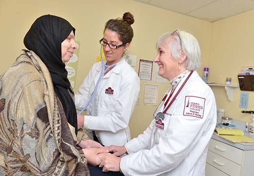 Student assists doctor with patient