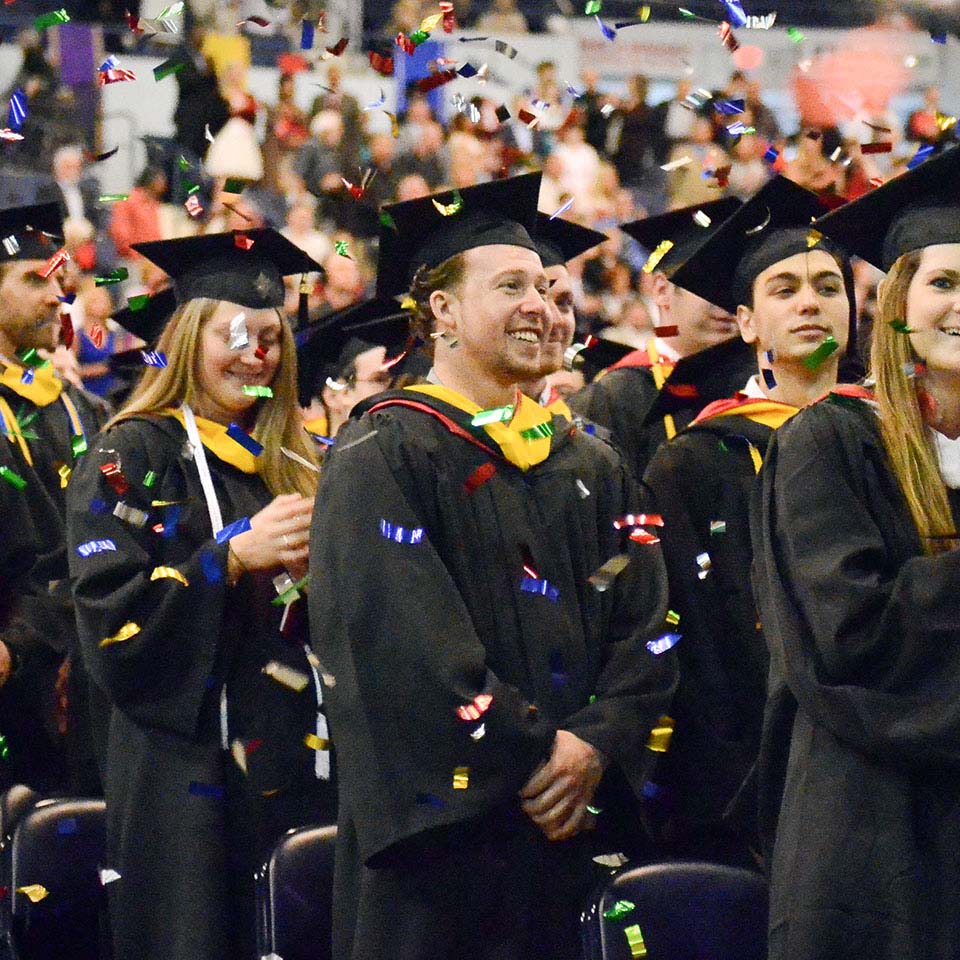 Confetti falls on student in caps and gowns following the Commencement ceremony.